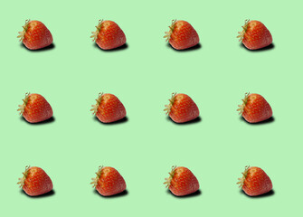 Group of strawberries on pastel green background.