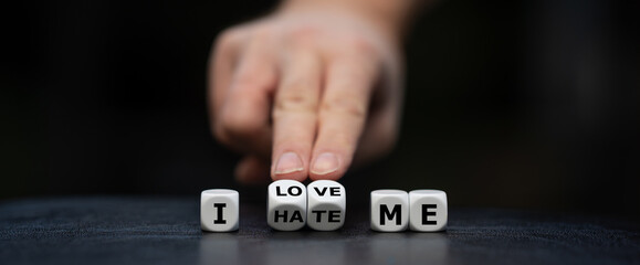 Hand turns dice and changes the expression "I hate me" to "I love me".