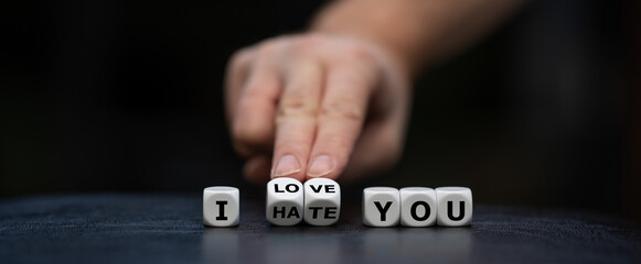 Hand turns dice and changes the expression "I hate you" to "I love you".