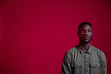 Obraz premium Young Black Man Posing in Studio on Isolated Red Background