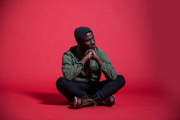 Young Black Man Sitting on Floor Thinking