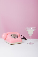 
antique pink phone and cocktail on the table