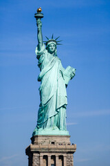 Fototapeta premium Statue of Liberty in NY Harbor on bright sunny day with blue sky