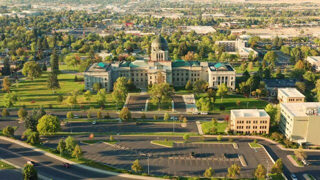 Aerial revealing shot of Helena and Montana State Capitol on a sunny afternoon with hazy sky caused by wildfires. The Montana State Capitol houses the Montana State Legislature.