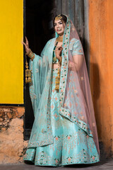 Pakistani Indian bride wearing wedding lehenga sharara design and jewelry. Outdoor fashion with Indian Bride.