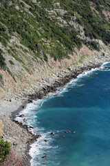 Costa selvaggia con spiaggia di sassi e mareggiata