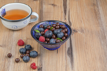 Blackberries coated with milk chocolate in a blue ceramic bow