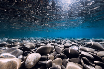 Obraz premium Underwater sea with stones, reflection and blue clear water. Ocean texture