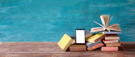 Stack of books and an e-book reader. E- Book, book fair,reading,realaxing,education concept. Free...