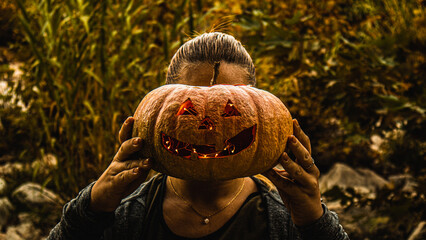 Blonde girl holding a Halloween pumpkin