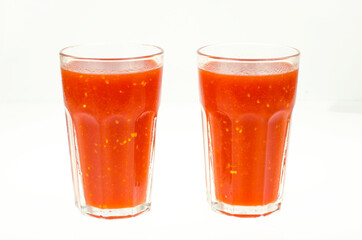Natural tomato juice in glass on white background.