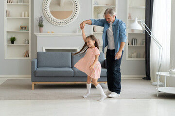 Handsome man spending time at home with his cute little daughter. Happy Father's Day! Dad and daughter.