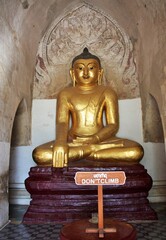 Buddha statue with sign reading Don't Climb at Ananda Temple in Bagan, Myanmar