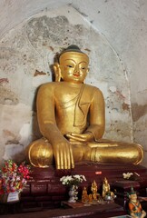 Gold color Buddha and smaller statues at Ananda Temple in Bagan, Myanmar