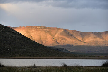 A fiery glow from the late afternoon sun against a rocky hill in the Karoo in South Africa