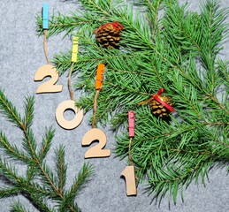 2021 New Year wooden numbers and spruce branches on a background of gray felt