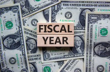 Concept words 'fiscal year' on wooden blocks on a beautiful background from dollar bills. Business...