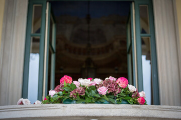 Fototapeta na wymiar Mazzo di fiori su davanzale di villa antica