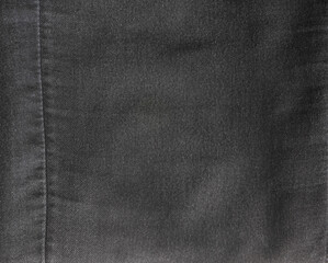 The texture of old black jeans. Denim. View from above.