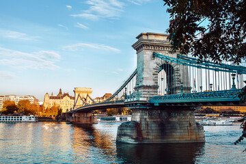 Obraz premium Chain Bridge in Budapest also known as Szechenyi lanchid connecting the Buda and Pest - the main Hungarian capital's parts separated by Danube river. Old Europe traveling concept photo.