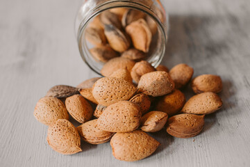 Almonds in a jar on wooden rustic table as background. Organic and healthy food.	
