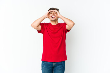 Fototapeta premium Young cool man laughs joyfully keeping hands on head. Happiness concept.