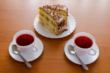 One white cup of tea and cake.