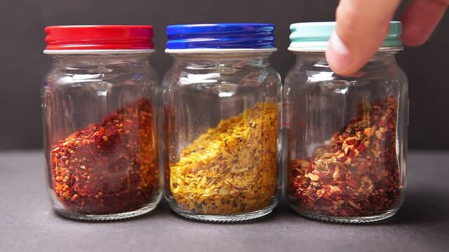 Kitchen utensils glass jars with dry spices. Sauce, curry, dried tomatoes