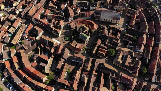 Small village central part, aerial shot of Eguisheim. Little square with church, small buildings around. Popular touristic attraction at Alsatian Vineyard Route, France