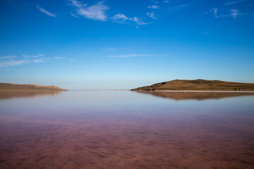 Pink salt lake Sasyk-Sivash, Yevpatoria, Crimea. The water of this lake is strongly saturated with salt and has a pink color. Very beautiful landscape with pink lake and blue sky with clouds.