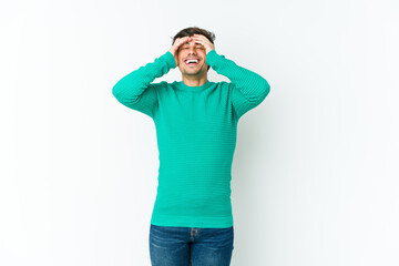 Fototapeta premium Young cool man laughs joyfully keeping hands on head. Happiness concept.