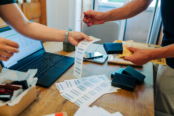 E-commerce colleagues labeling at desk in office