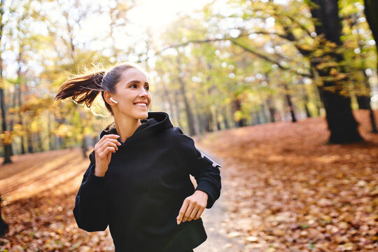 Young woman jogging in autumn forest