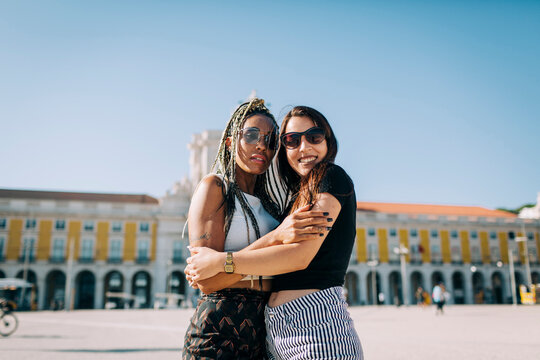 Women embracing each other at Praca Do Comercio against clear sky, Lisbon, Portugal