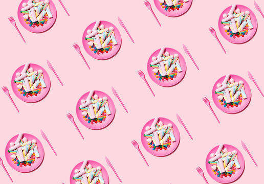 Pattern of plastic plates with marshmallows and candies