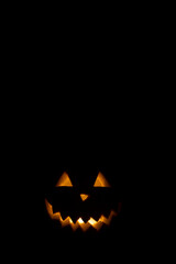Halloween pumpkin in the dark with lighted candle inside. horror theme and Hallowe'en.