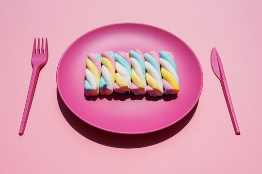Studio shot of plastic plate with row of twisted marshmallows