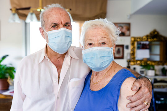Senior couple wearing protective masks at home