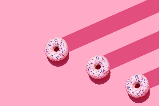 Studio shot of three sweet doughnuts with sugar sprinkles