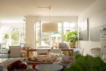 Living room with dining table against door and window during sunny day