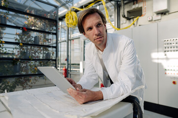 Scientist holding tablet in technical room of a greenhouse