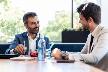Smiling business professionals discussing during meeting in restaurant