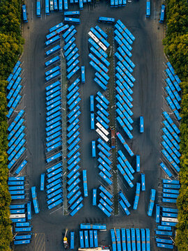 Aerial view of parking lot filled with blue buses