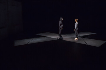 Male and female dancer performing comtemporary ballet on black stage