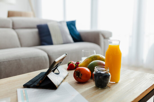 Fruit and drink kept with digital tablet on table at home