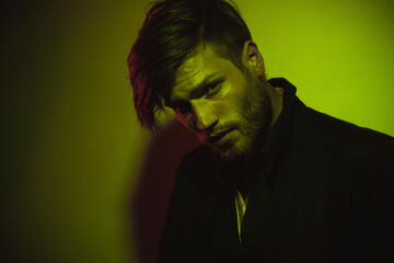 Handsome man standing against green background