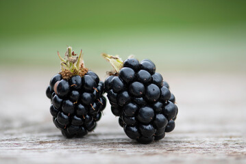 Blackberry or dewberry on wooden table against unfocused background