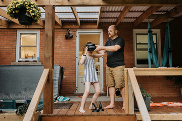 Girl with 3D glasses and father on veranda