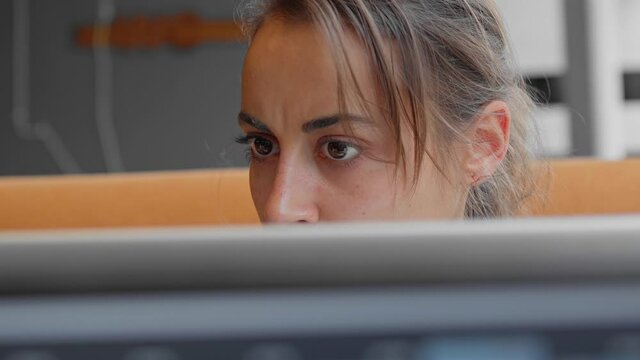 closeup eyes of focused and pensive, worried female scientist or laboratory assistant looks attentively and intently at monitor screen. medic thinking and solving problem of covid-19 vaccine