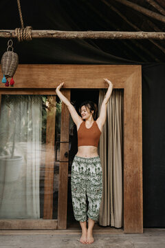 Smiling woman stretching her arms on terrace